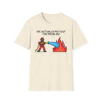 Beige t-shirt with a graphic of a firefighter putting out a fire and text 'WE ACTUALLY PUT OUT THE PROBLEM' on a white background.