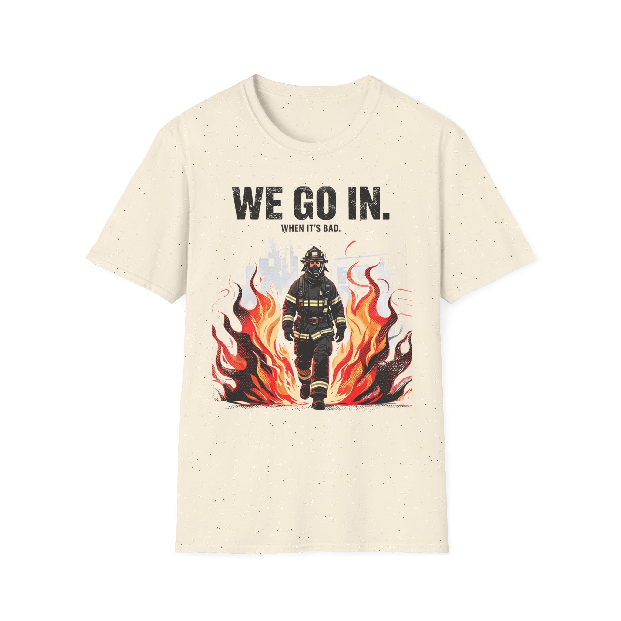 T-shirt with a firefighter graphic and text 'WE GO IN. WHEN IT'S BAD.' on a beige background